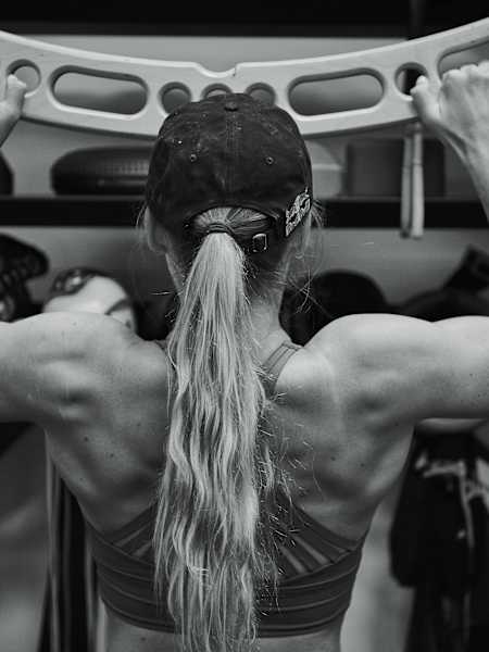 Une sportive réalise des tractions lors d’une séance de renforcement musculaire.