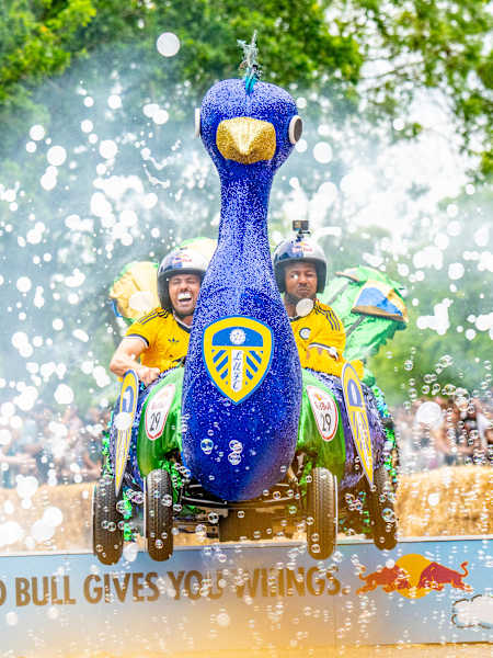 On 20th June 2026, Leeds United Football Club thrill crowds at Red Bull Soap Box in Alexandra Palace, London, racing their vibrant peacock-themed cart through bubbles and cheers