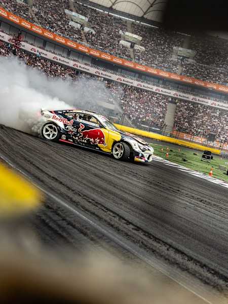 Conor Shanahan expertly drifts his Red Bull car through a smoky turn during the 2025 Red Bull Drift Masters Grand Finale in Warsaw, Poland, thrilling a packed stadium crowd.