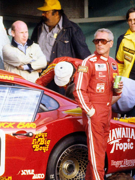 A photo of Paul Newman in his racing suit, by his car, getting ready to race the 1979 24 Hours Of Le Mans race.
