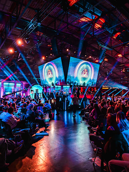 Spectators pack the vibrant arena at Red Bull Home Ground in Berlin, Germany on November 23, 2024, witnessing elite esports action beneath dazzling lights and screens