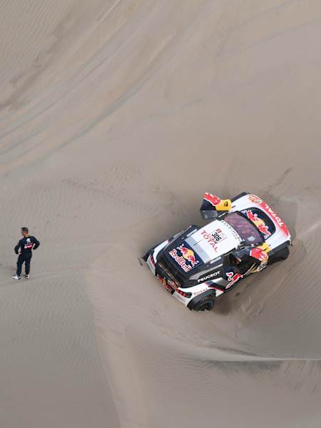 Sébastien Loeb y Daniel Elena con su Peugeot 3008 DKR Maxi medio enterrado en la arena.