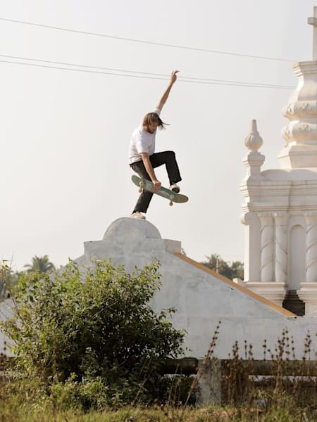 En skate trip à Goa en Inde pour "The Cury Connection", Rob Wootton pose un Fastplant en skateboard.