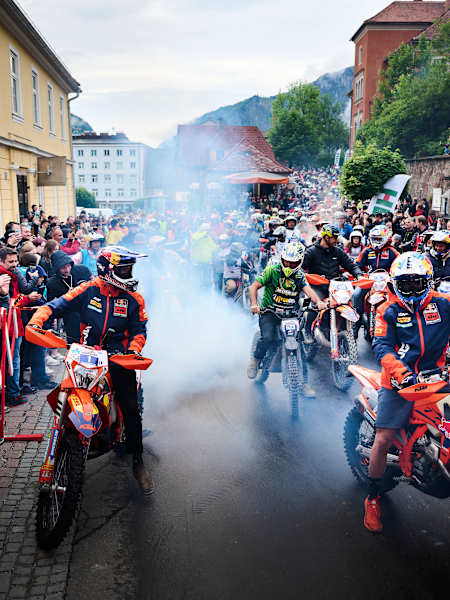 A dynamic scene captures Manuel Lettenbichler and Josep Garcia at the Red Bull Erzbergrodeo 2024 in Eisenerz, Austria, thrilling the crowd amid roaring motorcycles and adrenaline-fueled energy