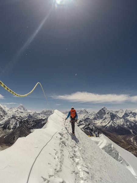 Renan Ozturk walks along a snowy ledge while climbing Climbing Lobuche peak in the Khumbu Mt Everest Himalaya.