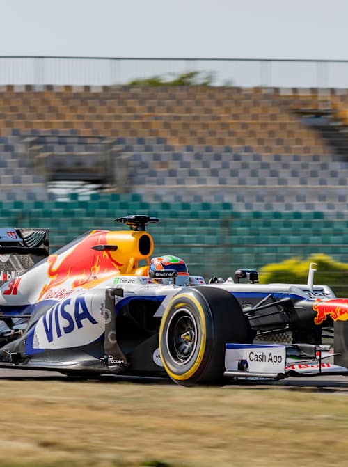 In 2026, Karun Chandhok races the striking Visa Cash App Racing Bull Formula One car at the Buddh International Circuit during Red Bull Moto Jam, pushing boundaries in Greater Noida, India