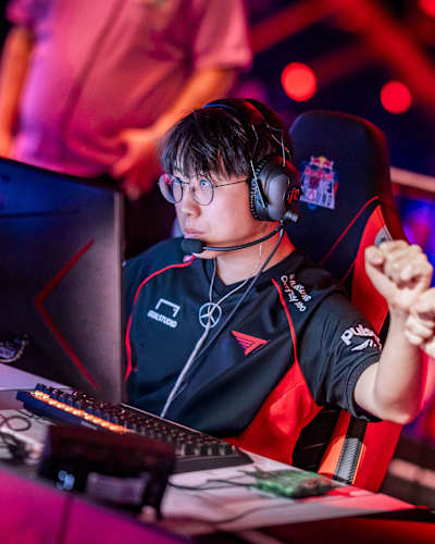 Kim « Meteor » Tae-oh, joueur de l'équipe T1, participe au Red Bull Home Ground à Berlin, en Allemagne, le 23 novembre 2024, les yeux rivés sur l'action qui se déroule derrière son écran de jeu.