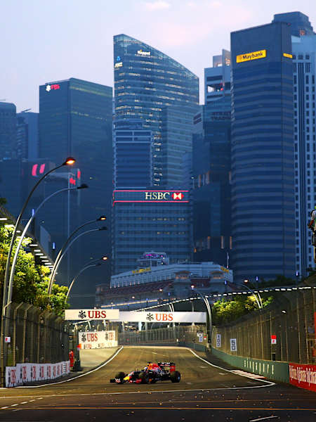 A Formula 1 car races on Singapore's urban circuit at night.