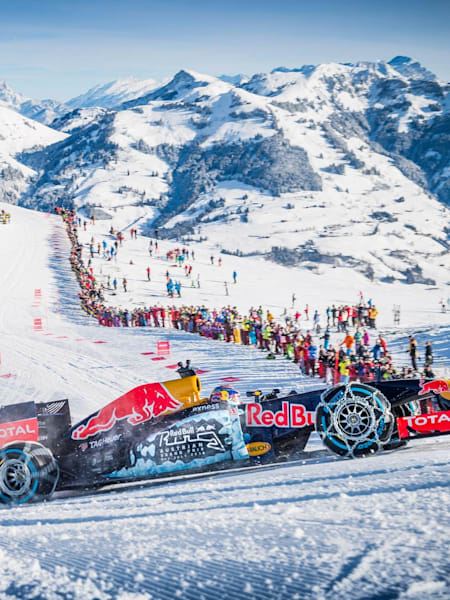 Max Verstappen za kierownicą bolidu Formuły 1, mającego opony ze specjalnymi łańcuchami, podczas pokazu na słynnym stoku Kitzbühel w Austrii.