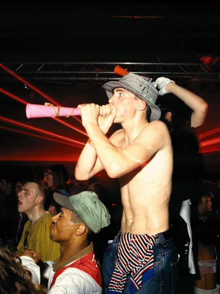 Lad blowing a horn standing on a table at The Trip, Astoria, London, 1988.