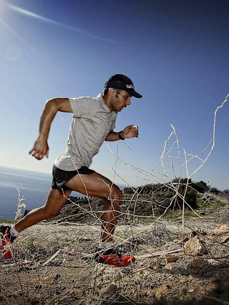 Trailrunner in Action mit dem Meer im Hintergrund.