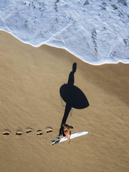 Mick Fanning en la playa con una tabla de surf.