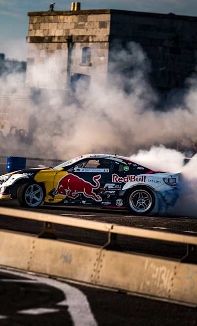 Red Bull Drift Pursuit ignites Spike Island, Cork in 2025 as Conor Shanahan performs a dramatic drift amid smoking tyres and cheering fans, capturing the energy of the event