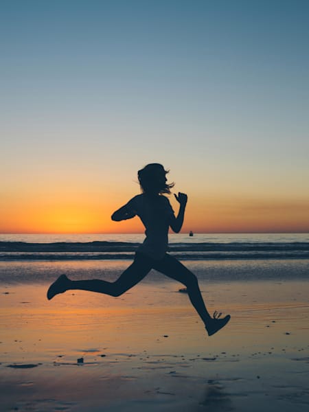 Una persona corre por la playa.