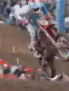 A motocross rider takes a jump out on a course.