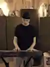 An image of Portland-based musician quickly quickly playing a keyboard.