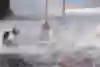 Oracle Team USA smashes a hull into the water and the crew is hit by a wave.