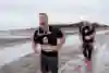 Ein Teilnehmer bei Red Bull Wattlauf macht sich mit schmerzverzerrtem Gesicht auf den Weg durch's Watt. 