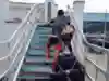One of the tandem men takes a bike up some steps