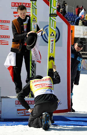 Adam Małysz i klęczący przed nim Simon Ammann w marcu 2011 r. w Planicy