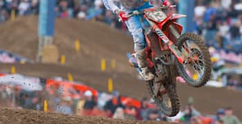 A motocross rider takes a jump out on a course.