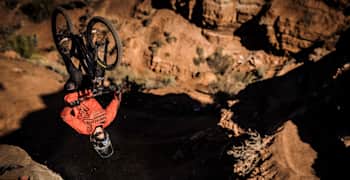 A rider backflips on the near-vertical slopes of Virgin, Utah, during Red Bull Rampage 2018.