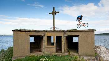 Uma foto de Danny Macaskill a fazer um tail whip off num edifício abandonado durante as filmagens de Way Back Home.