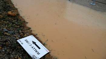 WRC atmosphere shot from Rally Portugal of a sign reading 'Rally Cars' in a puddle.