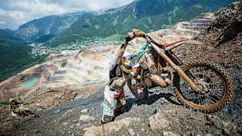 Foto dne - Dougie Lampkin tlačí motorku do kopce na Red Bull Hare Scramble