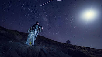 A wingsuit flier looks up at the Perseid meteor shower in La Palma