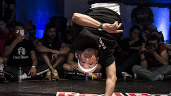 Un b-boy danse sur une main pendant un battle  la de la compétition de break Red Bull BC One.
