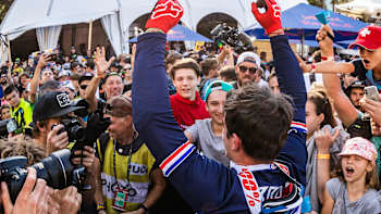 Le champion du monde de VTT Loïc Bruni célèbre avec ses fans lors d'une étape de la Coupe du monde UCI de descente.