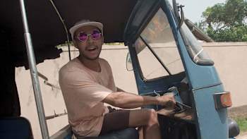 An image of a Tuk Tuk driver in his vehicle.