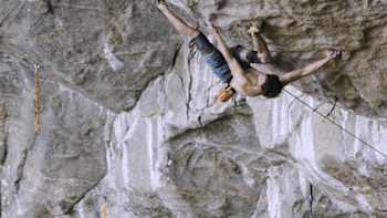 An image of Czech climber Adam Ondra in action on a rock.