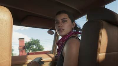 Captura de pantalla del tráiler de GTA 6 muestra a Lucía con un pañuelo rojo y un fajo de billetes en la mano. 