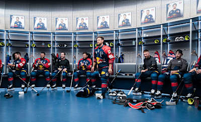 Patrick Hager und seine Mitspieler Red Bull München sitzen im Locker Room des SAP Garden.