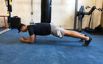 An athlete planking in the gym.