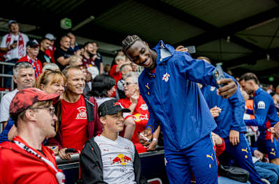 Ezechiel Banzuzi von RB Leipzig posiert für ein Selfie mit einem Fan.