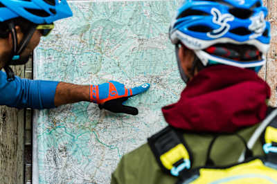 Le guide cycliste local Andreas Tonelli montre au visiteur allemand Tobias Woggon où se déroulera la prochaine course épique autour de Val Gardena, dans les Dolomites italiennes.