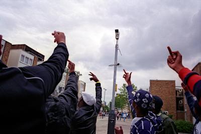Members of Get Money Quick crew walk past a CCTV camera, Kilburn, 2006