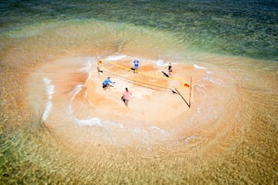 Players compete against each other in a beach volleyball match.