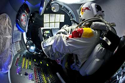Felix Baumgartner sedí v kapsuli počas stupania na misii Red Bull Stratos, 2012