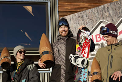 Travis Rice, Gigi Ruf and Nicolas Muller smile and hold snowboard for Supernatural 2012