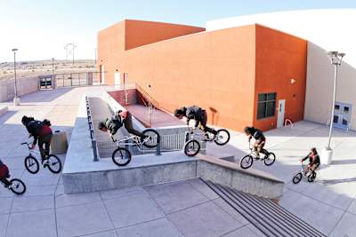 BMX rider Chad Kerley does a nose manual to barspin on a stair ledge