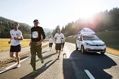 Participants run in front of the Wings for Life World Run Catcher Car in Oberwolz, Austria