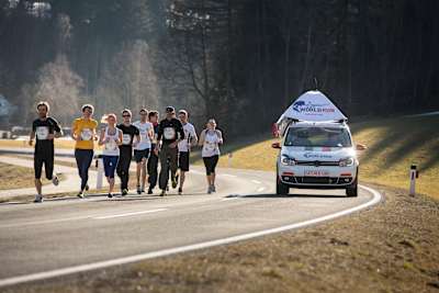 Participants run in front of the Wings for Life World Run Catcher Car in Oberwolz, Austria