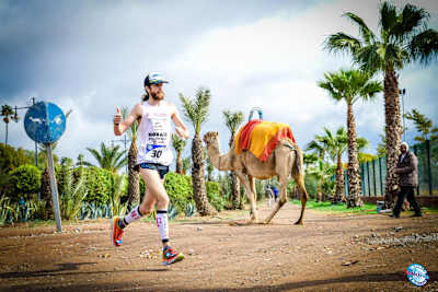 Michael Wardian runs past camel, Marrakech.