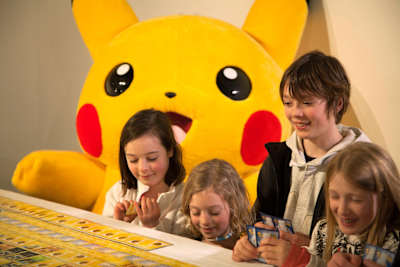 Kinder beim Aufbau des Sammelkarten-Mosaiks