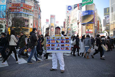 そんな渋谷の地に、仰々しいボードを抱えた道着姿の男がひとり。