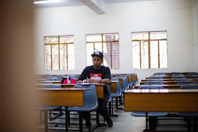 Gubbi writes in a book while sitting in a classroom in Christ Junior College at Hosur Road in Bengaluru